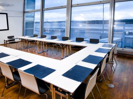 Kokoushuone, jossa pitkä pöytä ja monta tuolia.