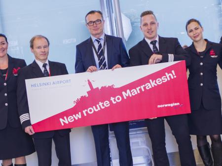 Norwegian employees holding a signboard about new flight route.