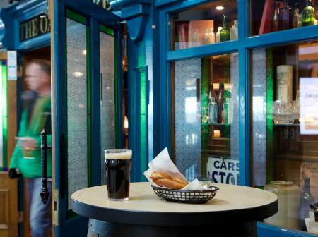 Oak Barrel store front with drink and food on barrel table.