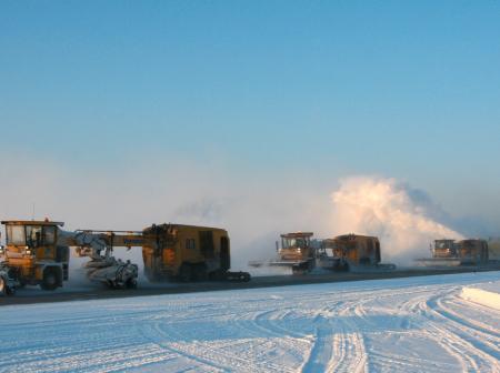 Snowplow machines on snowy day.