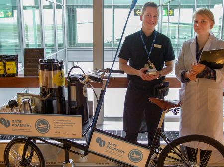 Two persons in front of a popup coffee shop.