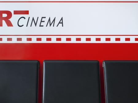 Black seats in front of painted wall.