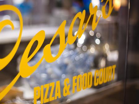 Vinyylitarra ikkunassa, jossa lukee Cecar's pizza & food court.