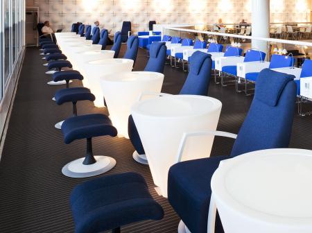 Lounge with round tables surrounded by chairs.