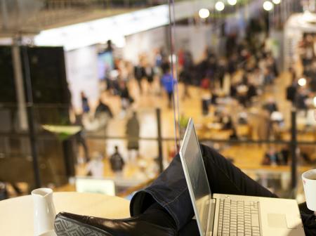 Passenger working from a cafe while drinking coffee.