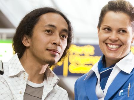 A woman guiding a man at airport.