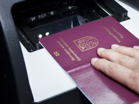 Henkilö laittaa passin skanneriin.