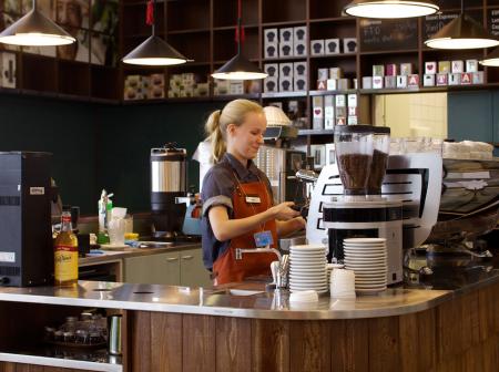 A woman brewing coffee.