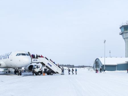 Passengers boarding a plane during winter at Kittilä Airport.