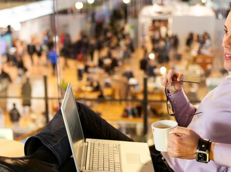 Passenger working from a cafe while drinking coffee.