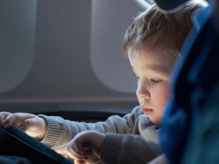 Taapero käyttää tablettia lennon aikana.