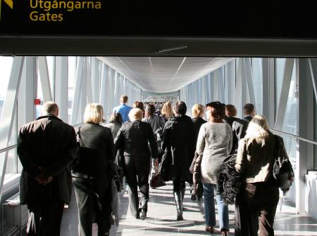 Passengers walking to non-Schengen gates through a glass bridge.