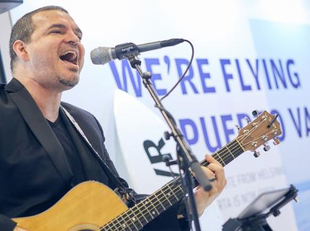 A man playing guitar and singing.