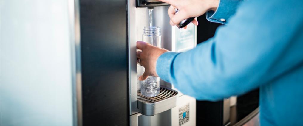 Passenger is taking water from water machine