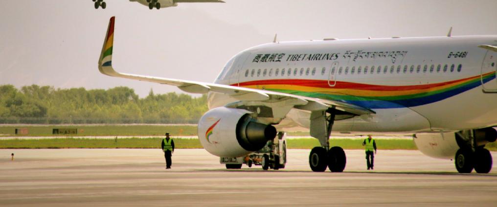 Kaksi Tibet Airlinesin lentokonettam, joista toinen on ilmassa ja toinen maassa.