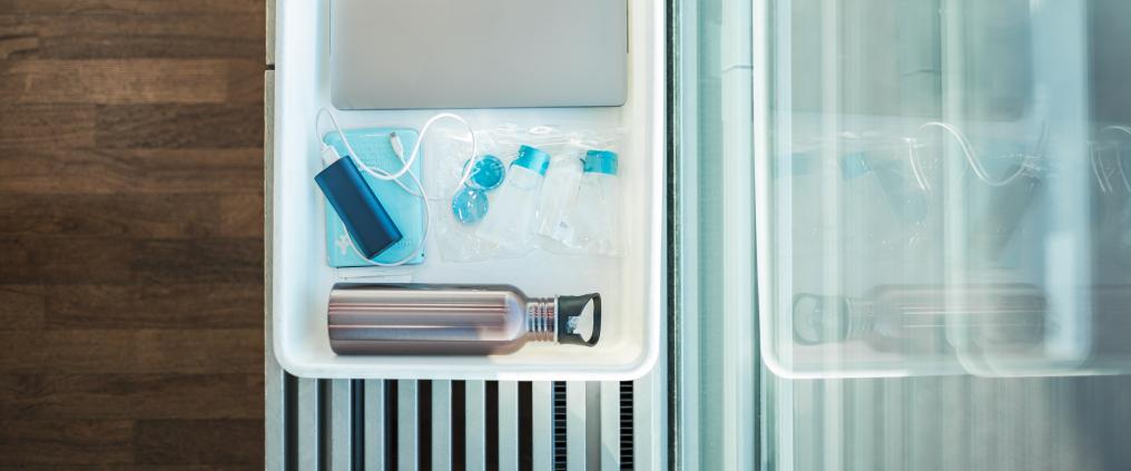 Liquid products and electronics on a security control tray.
