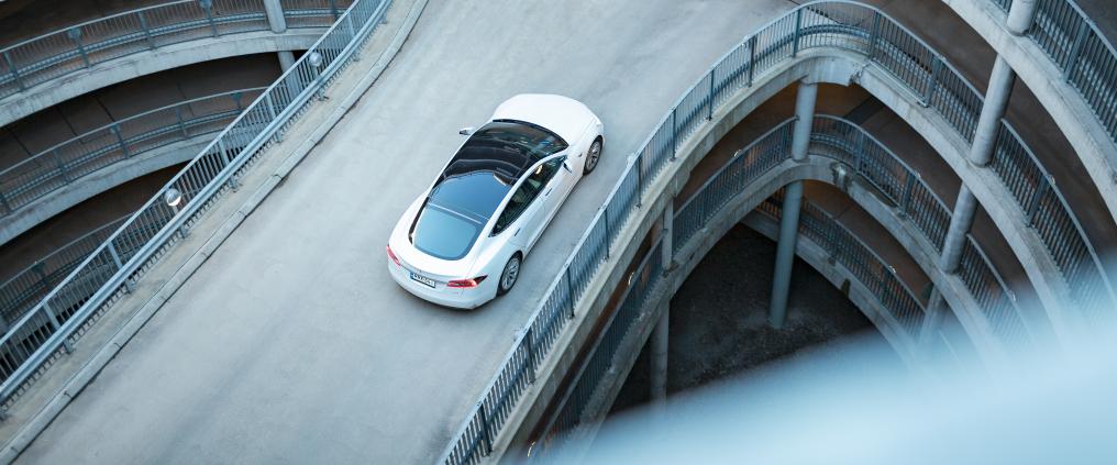 White car driving towards exit at P5 parking hall.