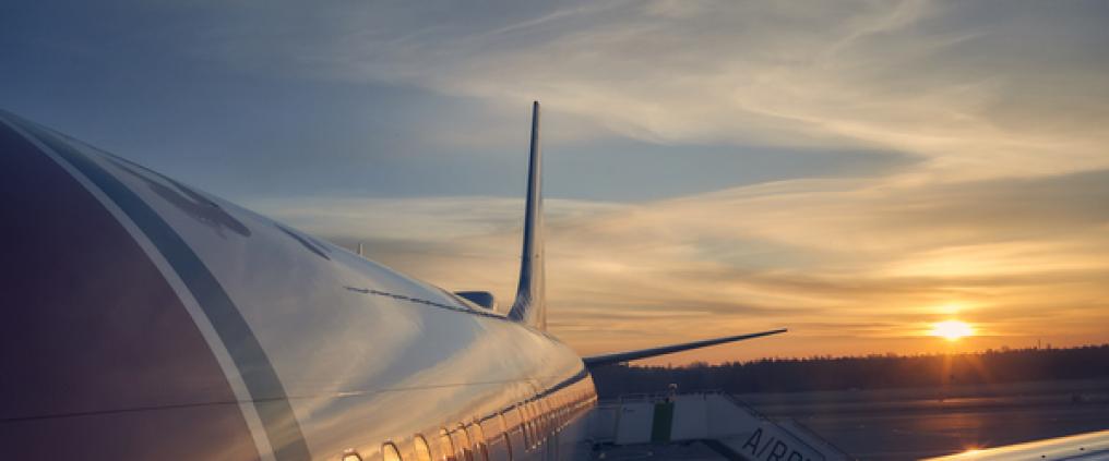 Norwegian-koneen kylki ja auringon lasku.