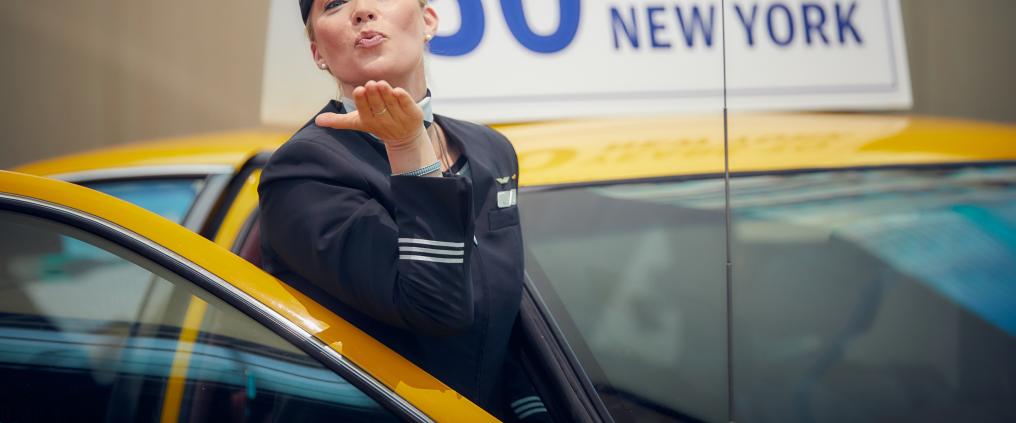 Purser blowing a kiss while getting off a yellow cab.