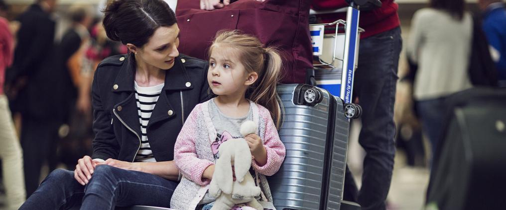 Lapsi istuu matkatavarakärryssä