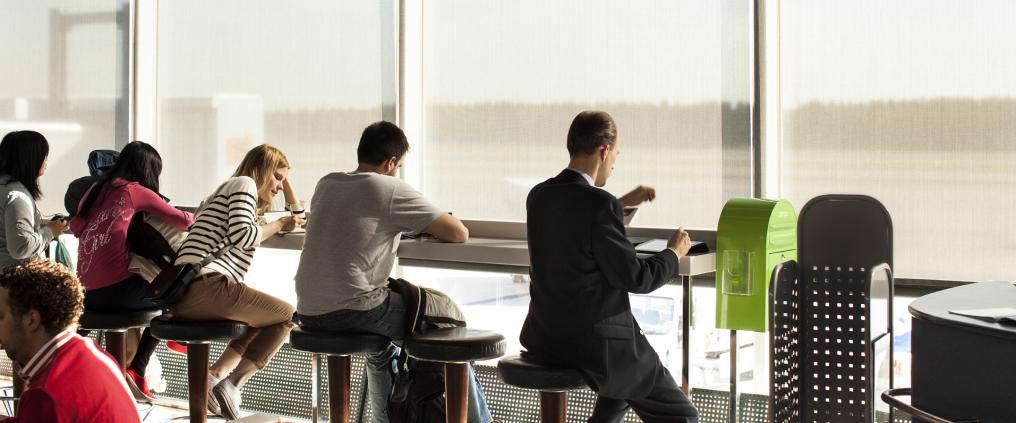 Passengers sitting by the window at Helsinki Airport