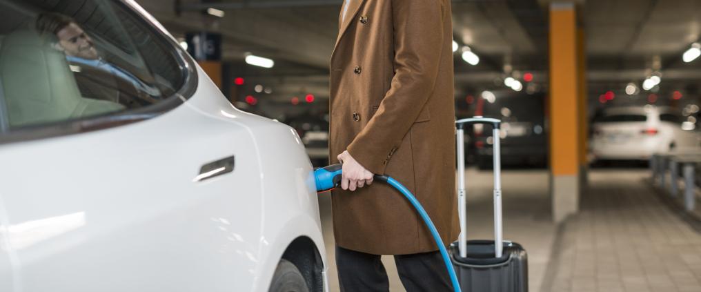 Mies lataamassa sähköautoa