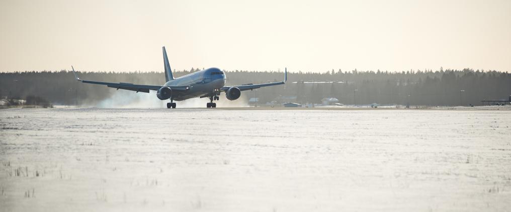 Lentokone laskeutuu talvisessa maisemassa