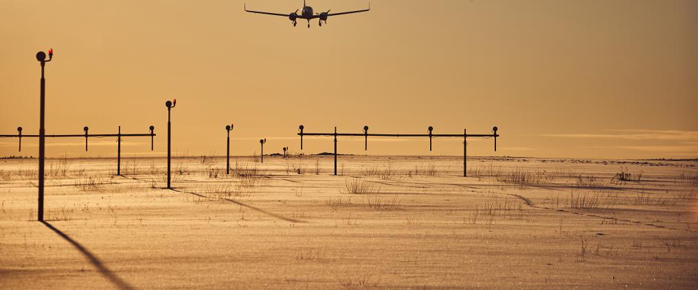 A plane landing in the sunset