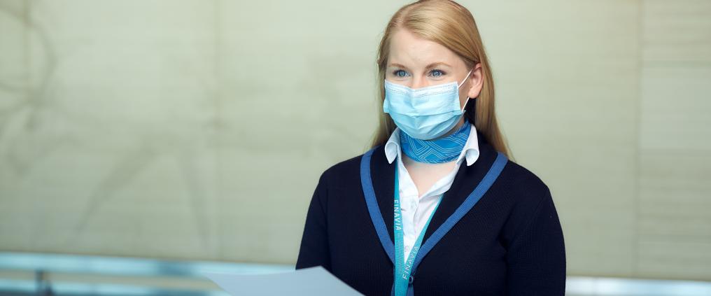 Asiakaspalveluhenkilö jakaa ohjetta lentoasemalla