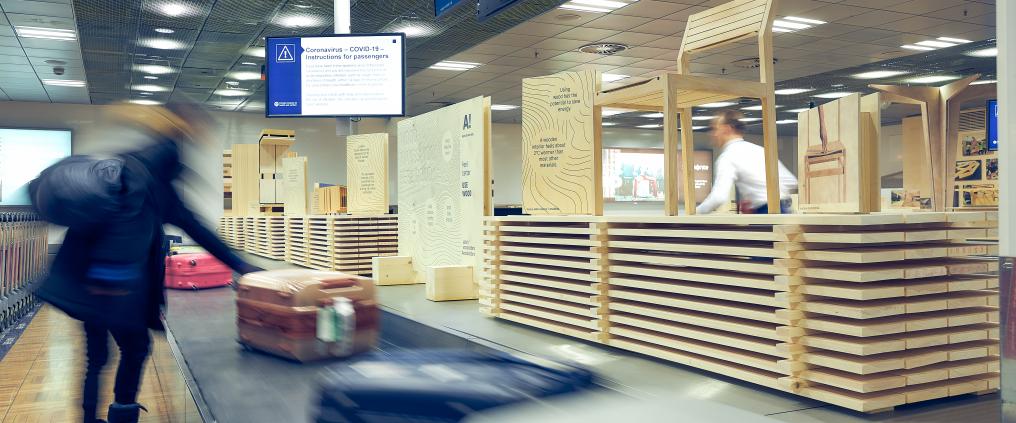 Henkilö ottaa matkalaukun pois matkatavarahihnalta