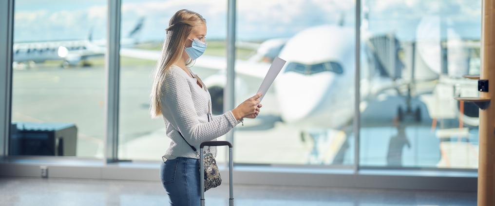 Nainen seisoo Helsinki-Vantaan lentoasemalla. 