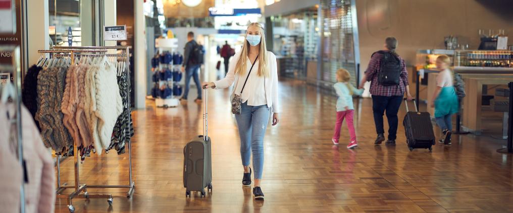 Nainen kävelee myymälän ohi Helsinki-Vantaalla