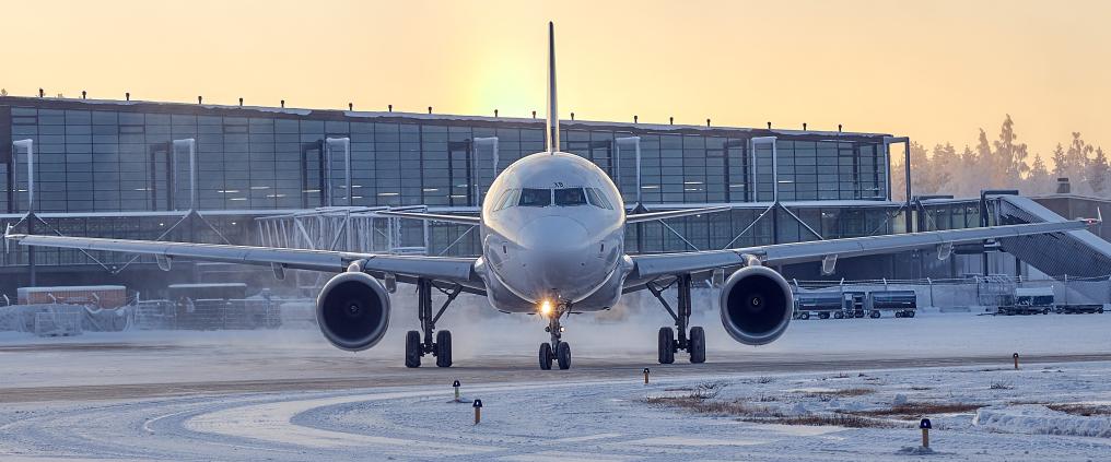 Lentokone ilta-auringossa, lumisella asematasolla
