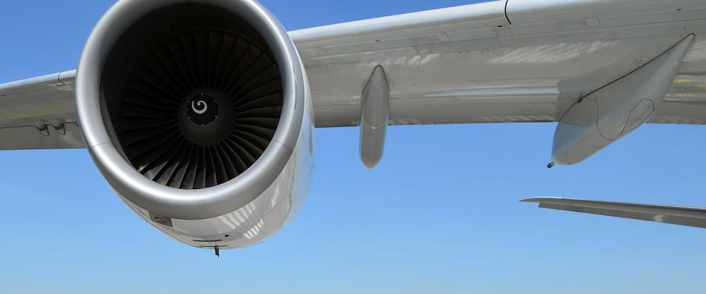 Lähikuva lentokoneen moottorista ja siivestä.