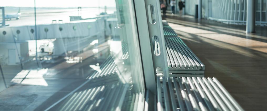 Ikkunan läpi näkyvä asemataso ja lentokone.