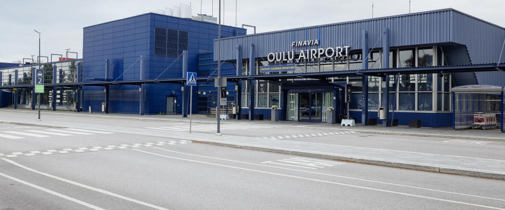 Oulun lentoaseman pääsisäänkäynti ja sininen terminaalirakennus.