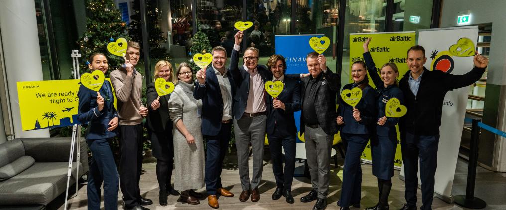 Air Balticin reittiavajaistunnelmia. Kuvassa monta henkilöä pitävät kädessään kuvakoristeita.