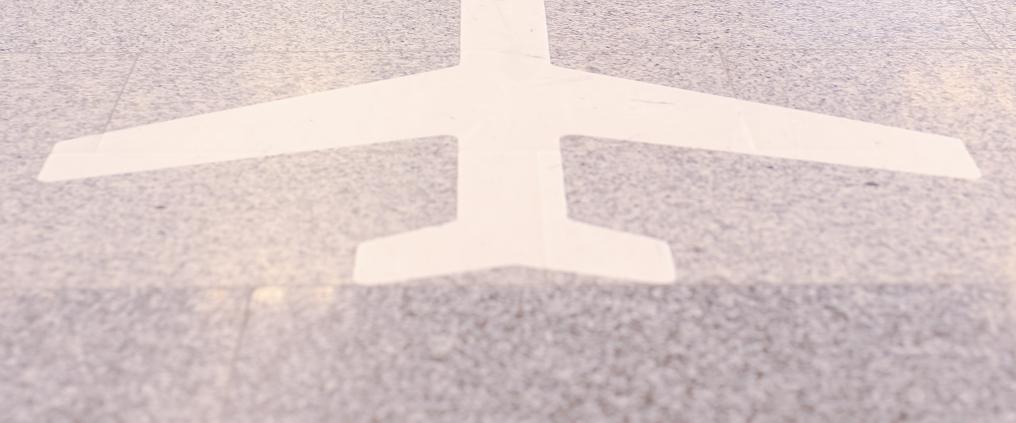 Lentokoneen muotoinen tarra kivilattiassa