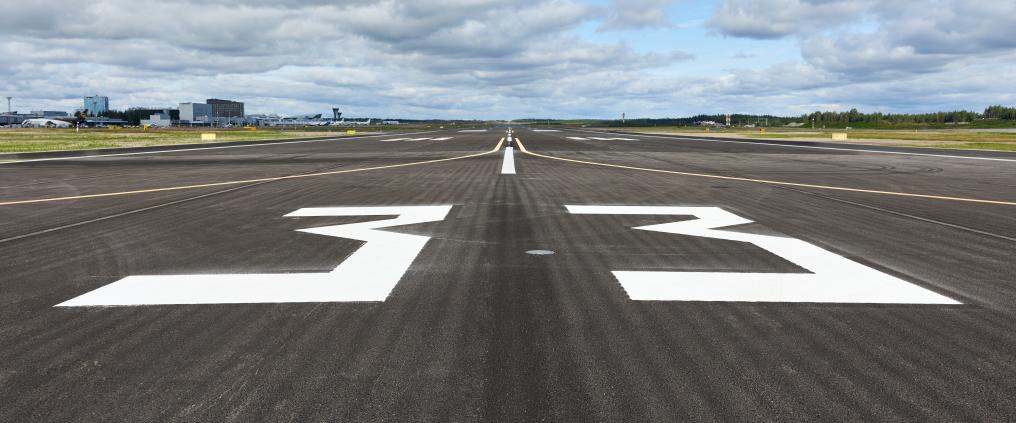 Musta asfalttinen kiitotie, jossa valkoisella maalattu numero 33.