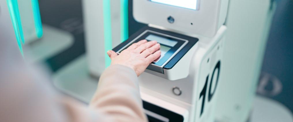 Käsi pitelee passia uudessa EES-järjestelmän lukijassa.