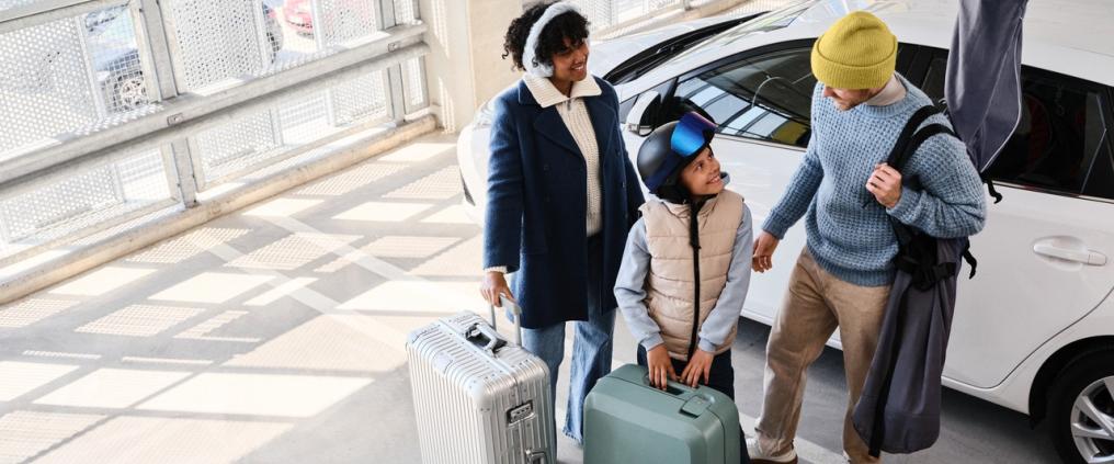 Perhe Helsinki-Vantaan lentoaseman pysäköintitalossa lähdössä matkalle