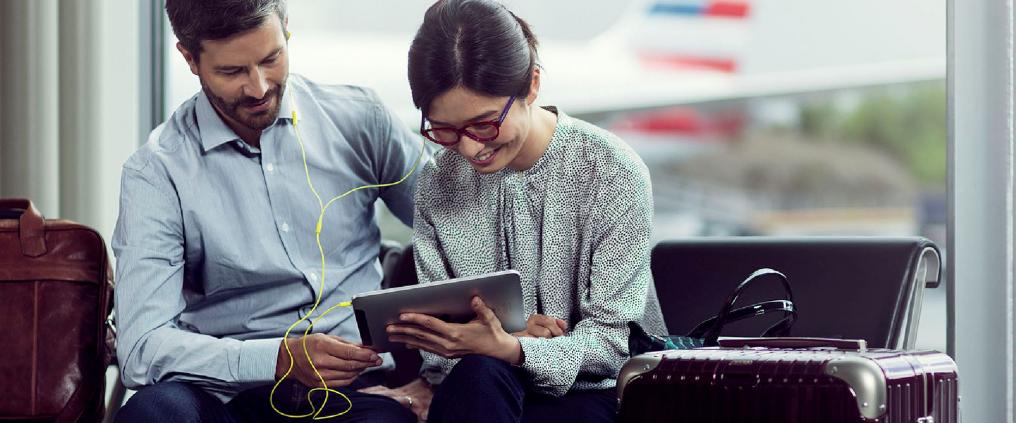 Man and woman watching something together from a tablet.