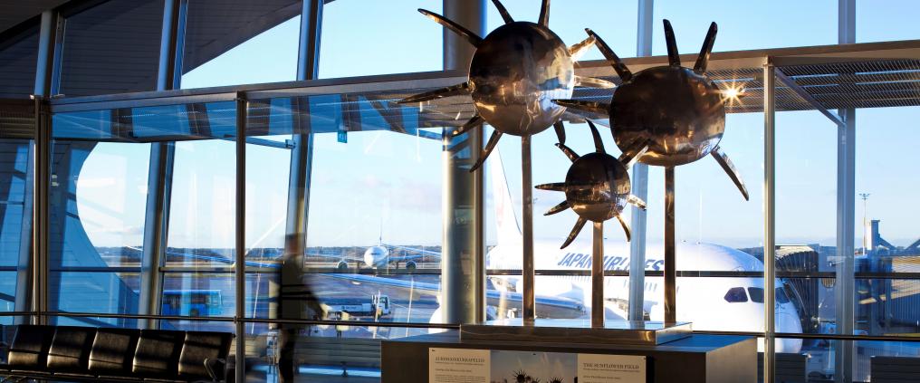 Metallinen taideteos auringonkukista lentokentällä.