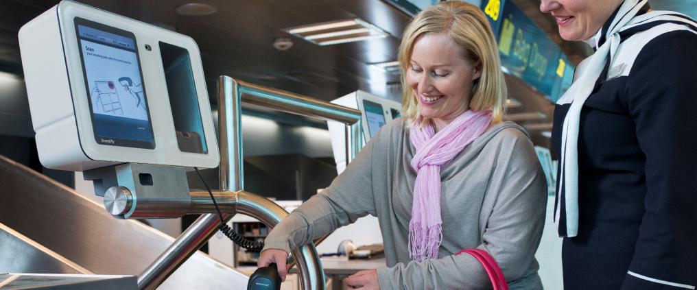 Woman using self bag drop service at airport.