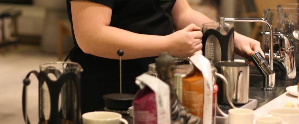 A woman making a coffee drink.