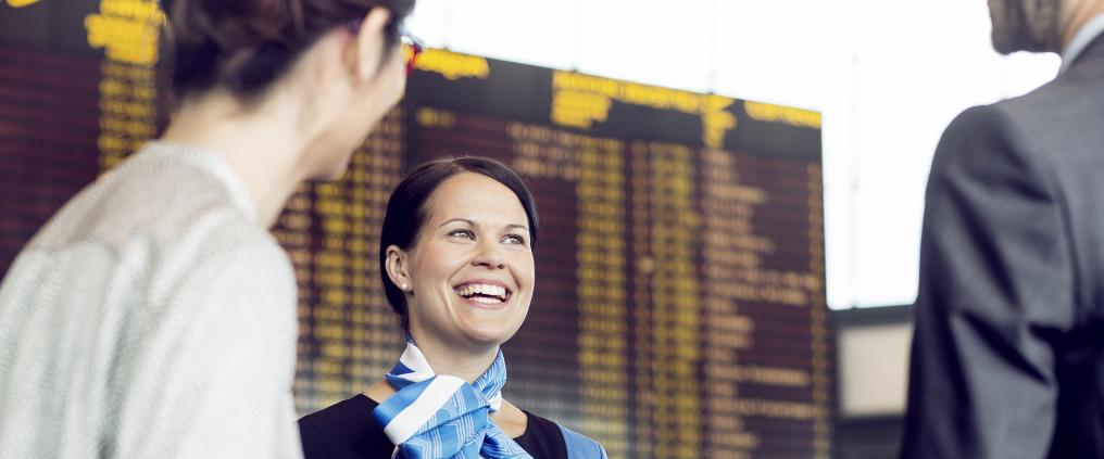 Smiley passenger adviser guiding her customers.