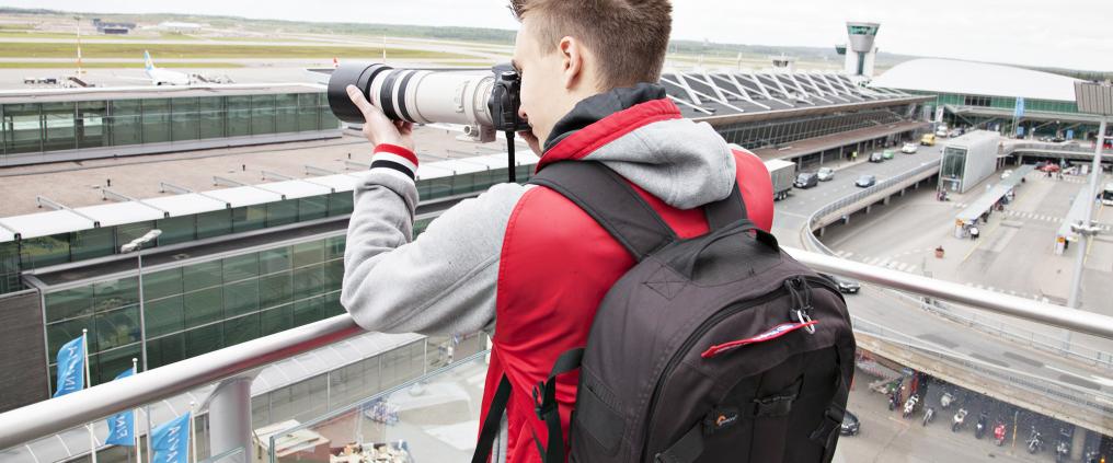 An airplane spotter taking pictures.