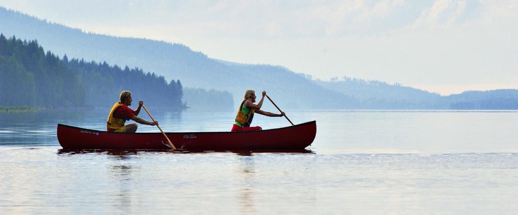 Two people canoeing in one canoe in the nature.