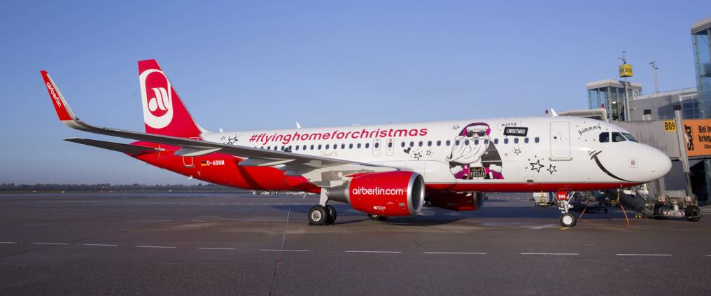 Christmas themed Airberlin airplane parked at gate.