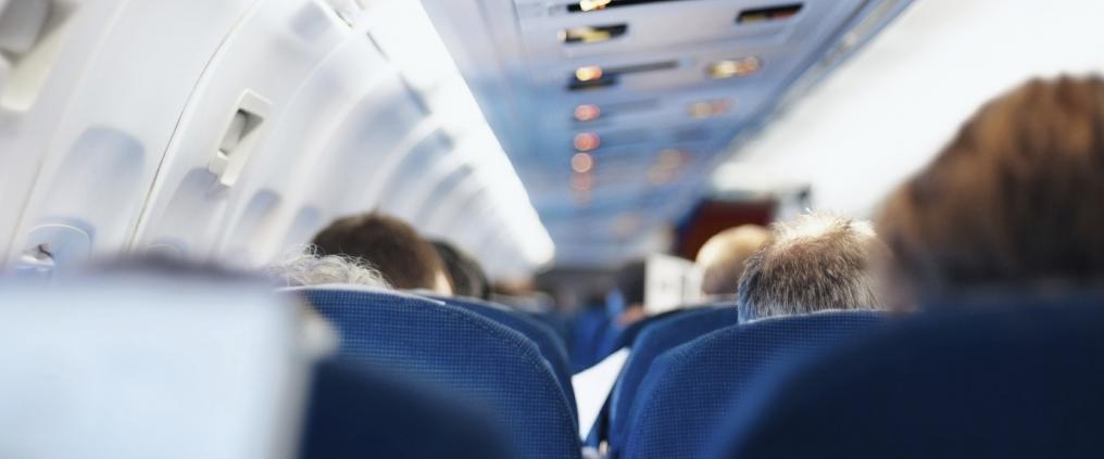 Passengers sitting in airplane cabin.